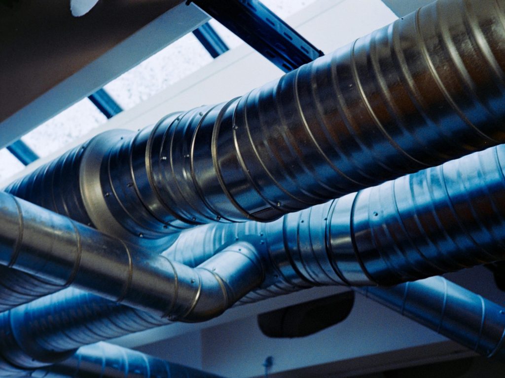 Close-up of a modern metallic ventilation system in an industrial setting.